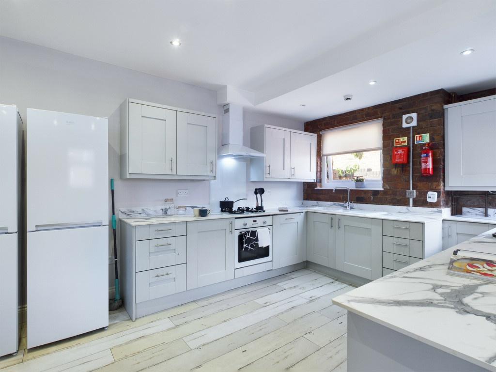 Bright and modern kitchen with white cabinetry,...