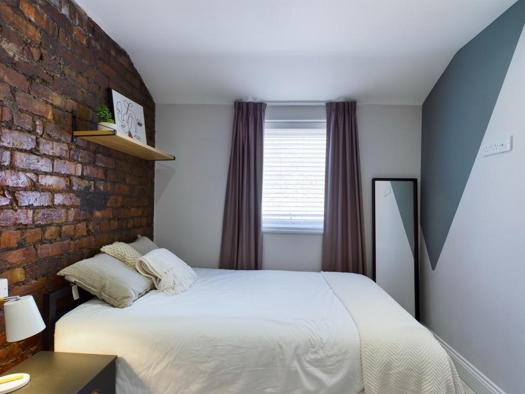 A bright, well-maintained bedroom with a stylis...