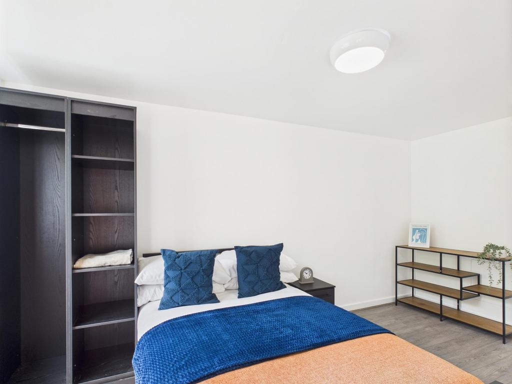 Bright, simply styled bedroom with a comfortabl...