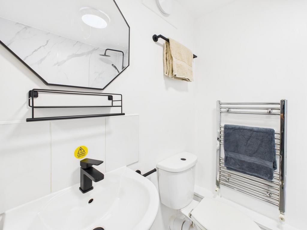 Bright, modern bathroom with clean white tiles,...