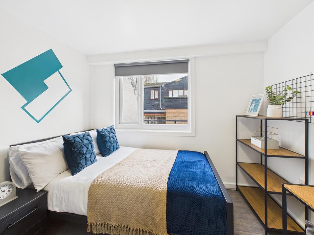 Bright, neatly styled double bedroom with a com...