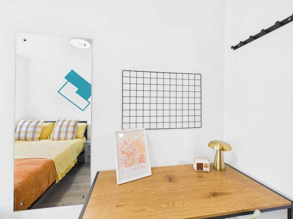 Bright, modern bedroom with a tidy study area f...
