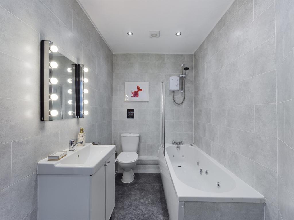 A spacious and stylish bathroom featuring a rel...