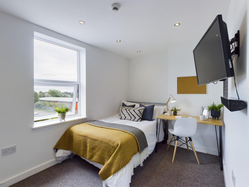 A bright and tidy double bedroom featuring mode...