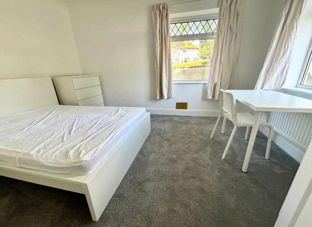 A bright and spacious double bedroom with a mod...