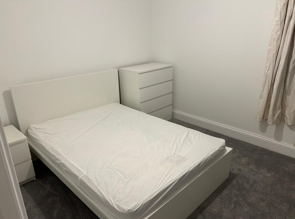 A spacious and tidy double bedroom with modern ...
