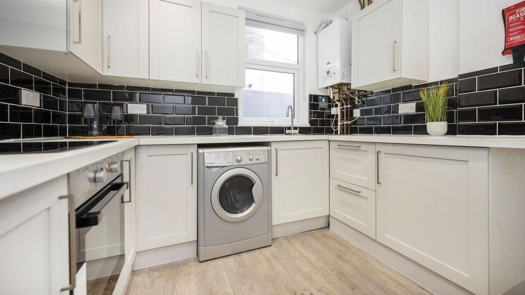 A modern and clean kitchenette with stylish bla...