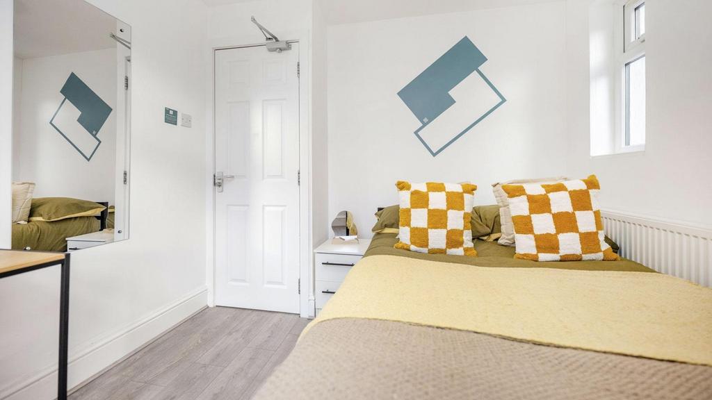 A bright and inviting double bedroom featuring ...