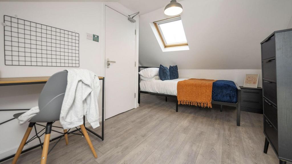 A bright and tidy double bedroom featuring a co...