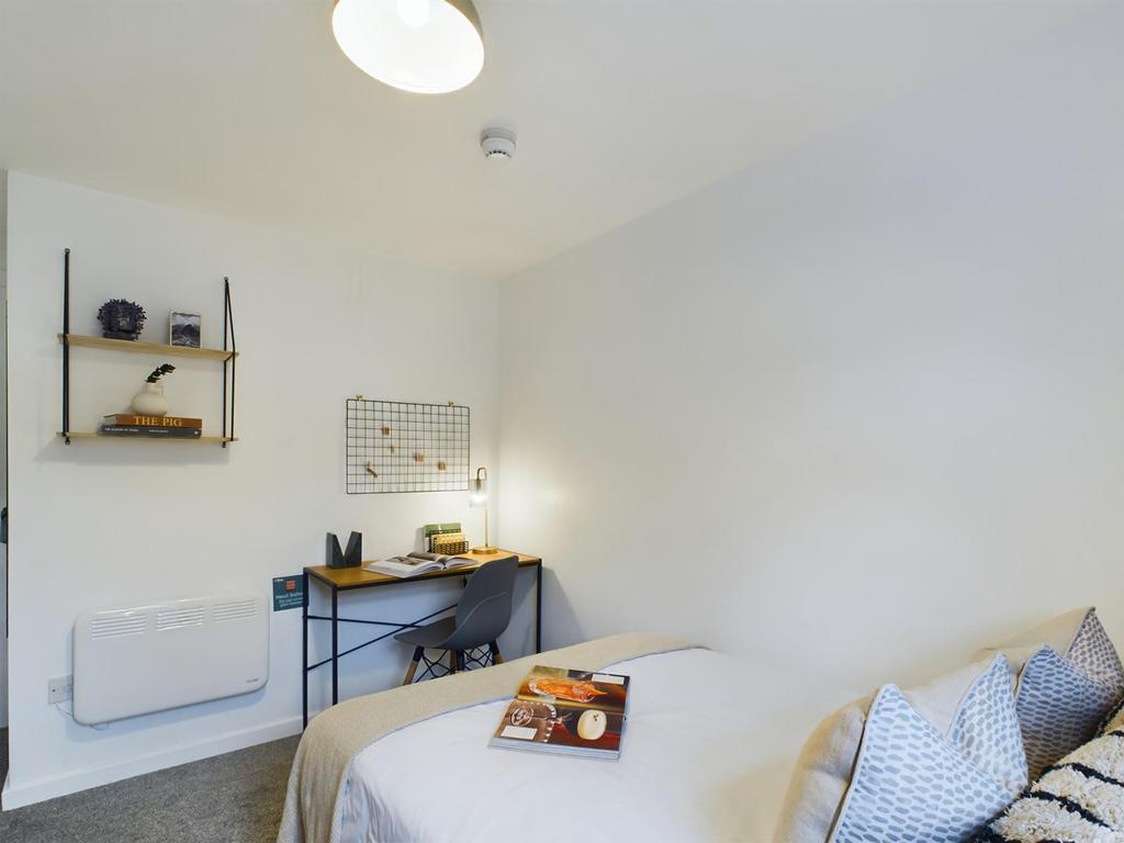 A bright and tidy double bedroom featuring a wo...