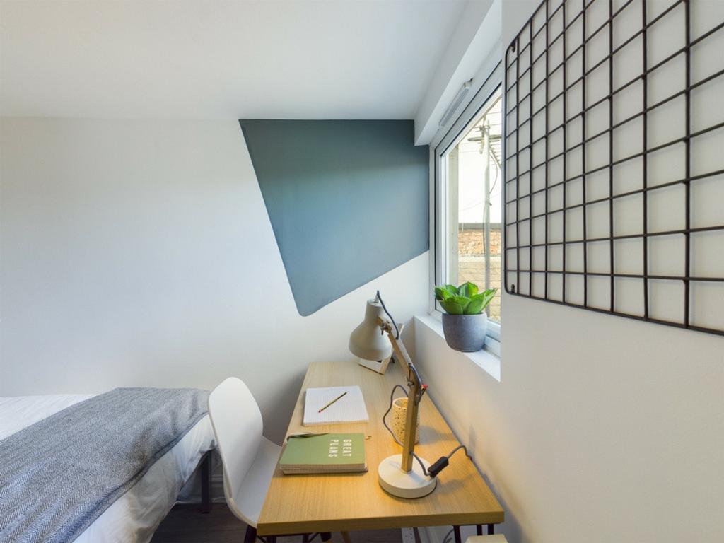A bright and tidy double bedroom featuring a st...
