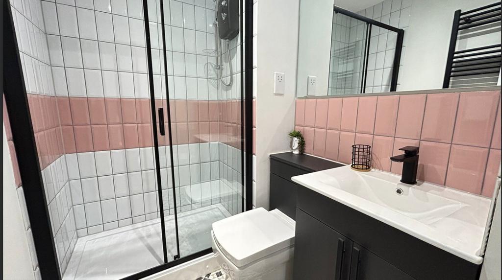 A modern bathroom featuring a walk-in shower, s...