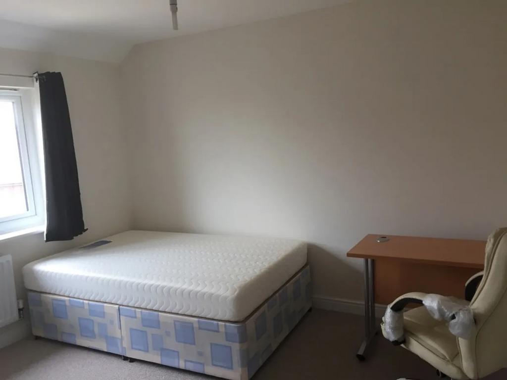A spacious double bedroom featuring a comfortab...