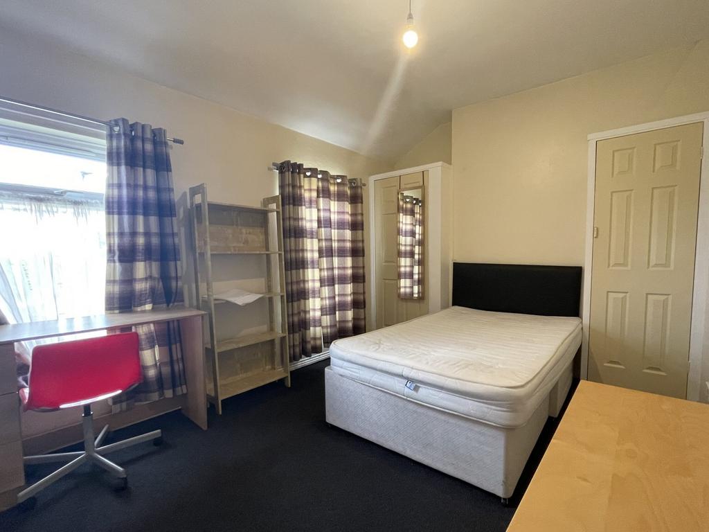 A spacious and well-lit double bedroom with a s...