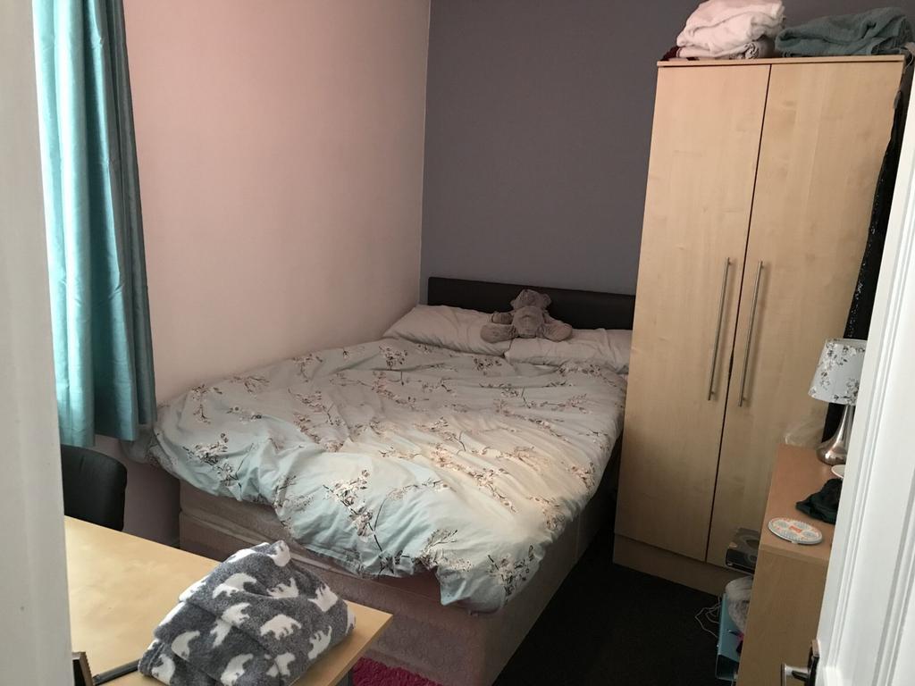 A cozy double bedroom with a comfortable bed, p...