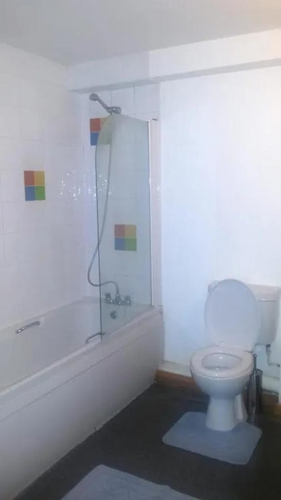 A clean and bright bathroom featuring a bathtub...