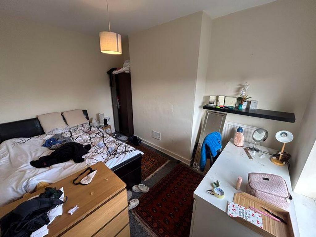 A cozy double bedroom with ample space and natu...