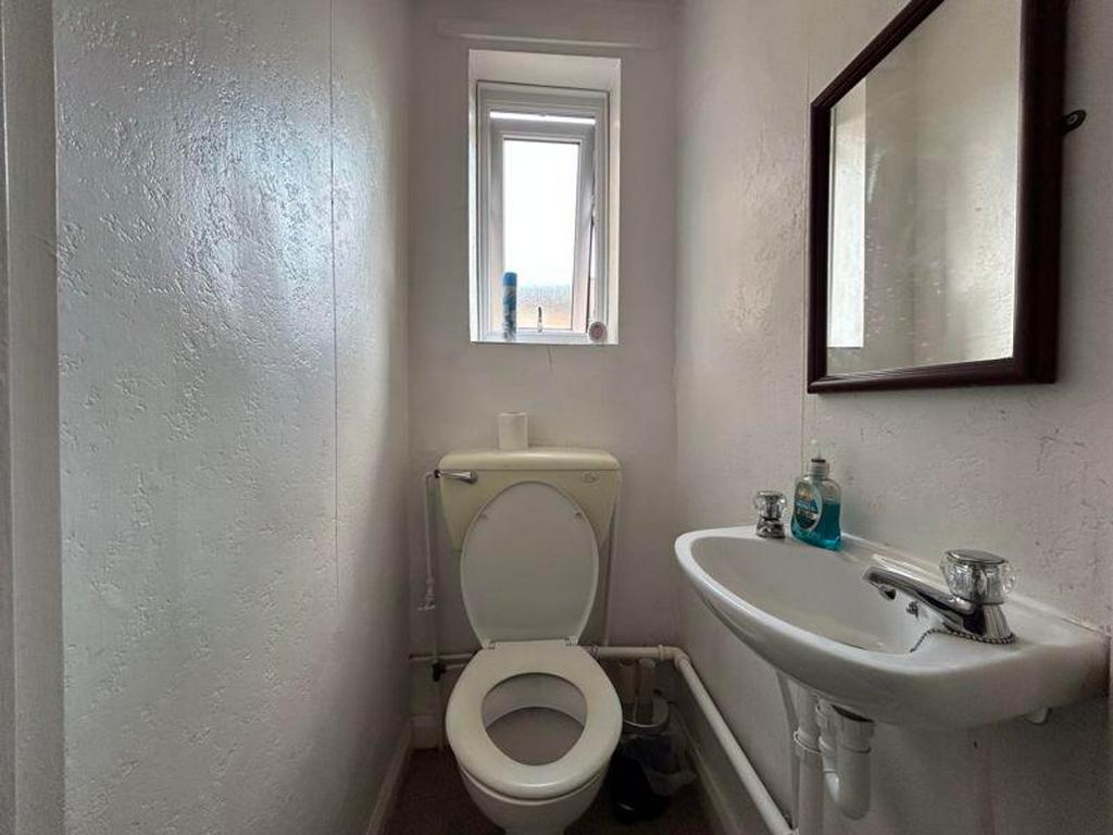 A tidy single toilet with a clean and bright am...