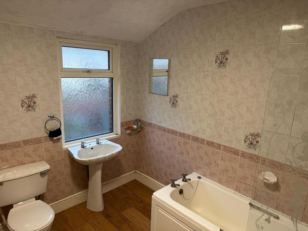 A well-maintained bathroom featuring a bathtub ...