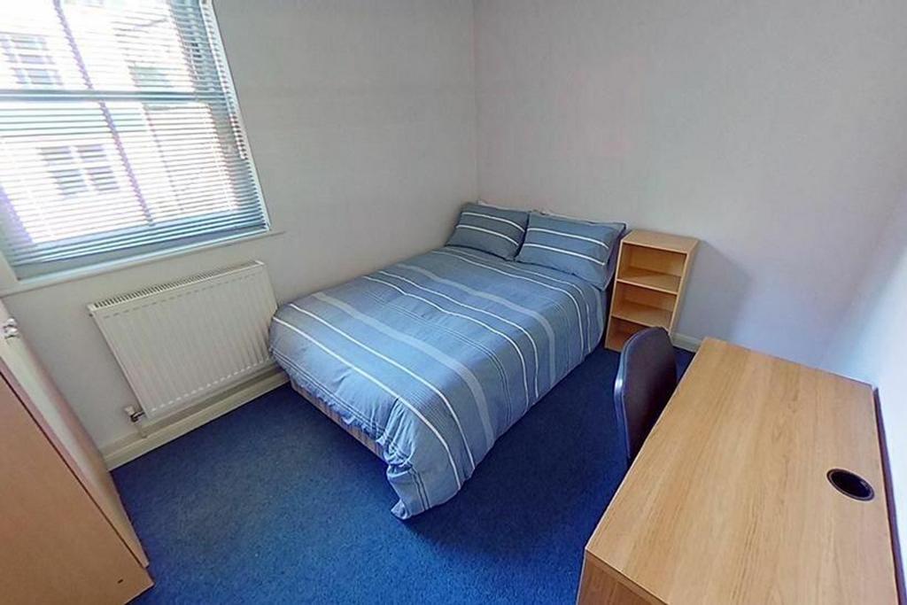 This cozy double bedroom features a comfortable...