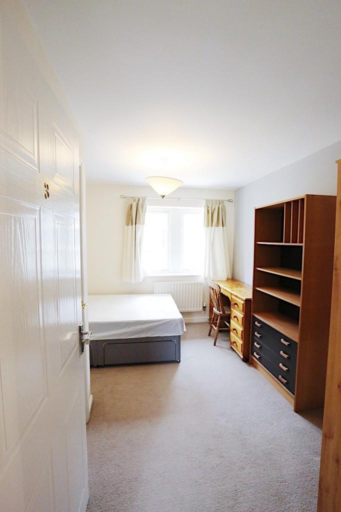 Bright, neutrally decorated bedroom with a doub...