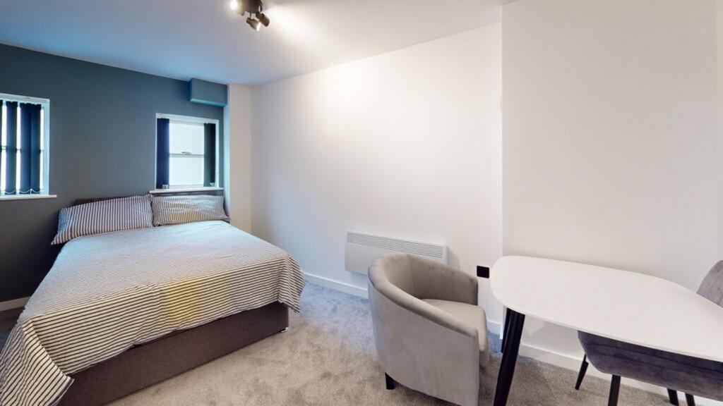 A spacious and well-lit double bedroom perfect ...