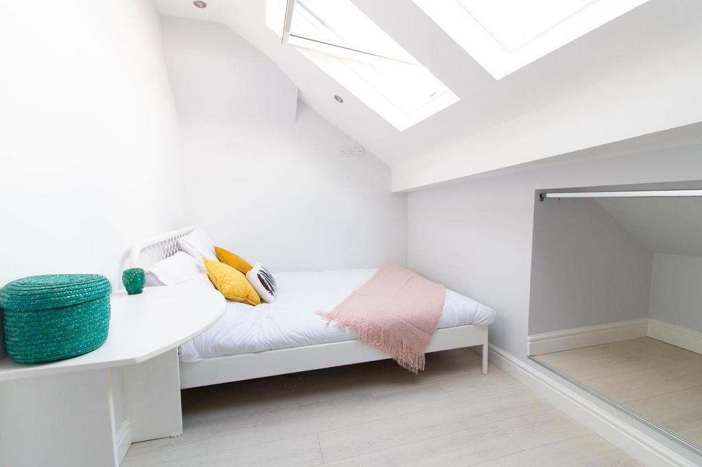 A bright and inviting double bedroom with styli...