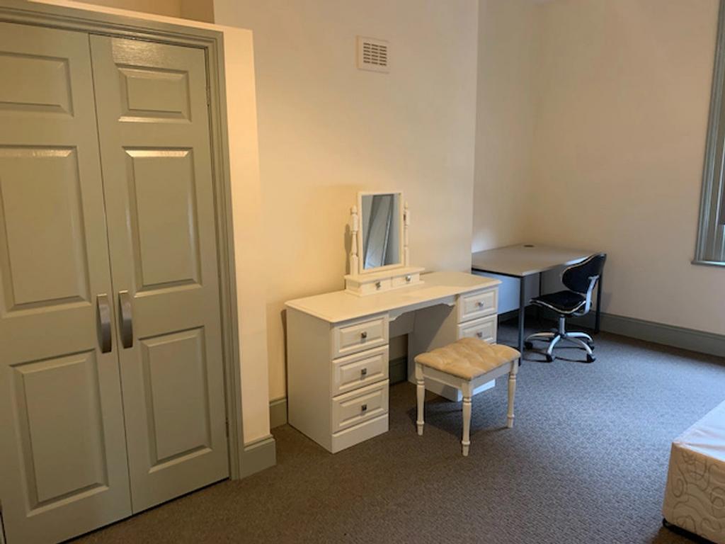 A bright and tidy double bedroom featuring a de...