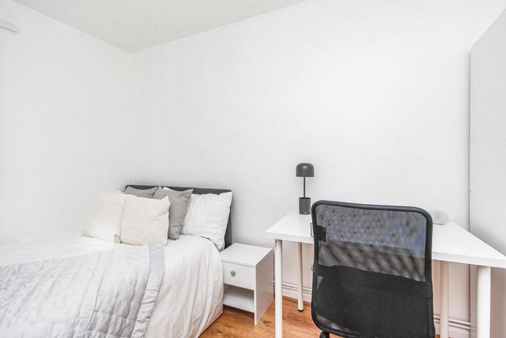 This cozy double bedroom features a comfortable...