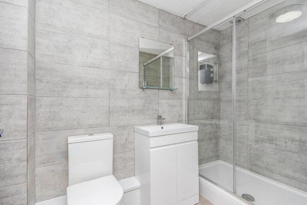 A modern bathroom featuring sleek grey tiles, a...