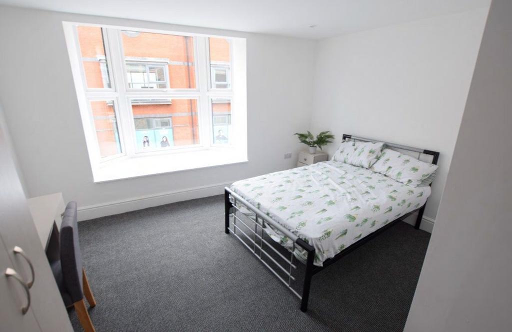 A bright and spacious double bedroom featuring ...