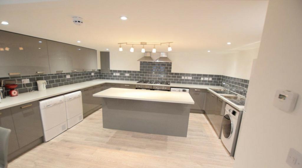 A spacious and modern kitchen featuring sleek c...