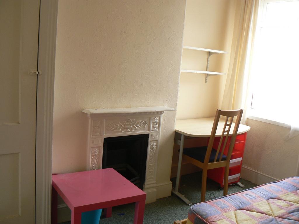 A cozy double bedroom featuring a charming fire...