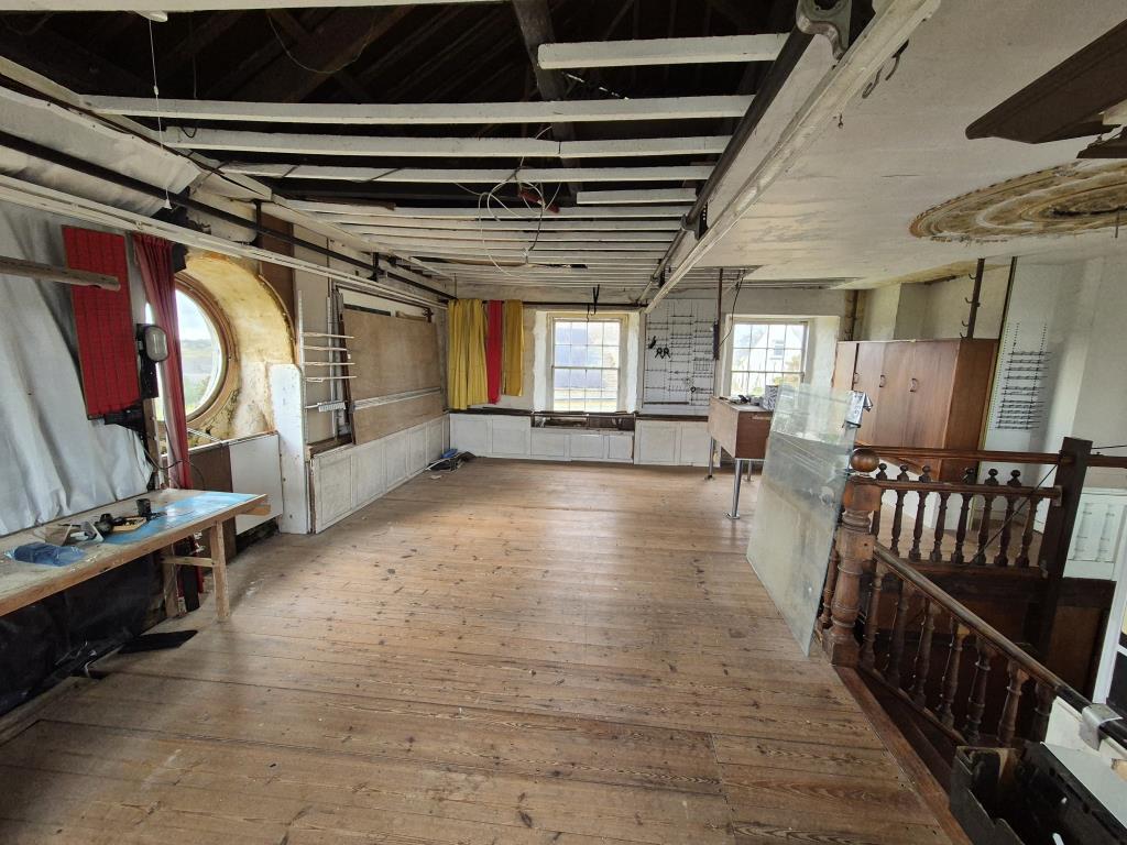 Open plan room with wooden flooring and multiple w