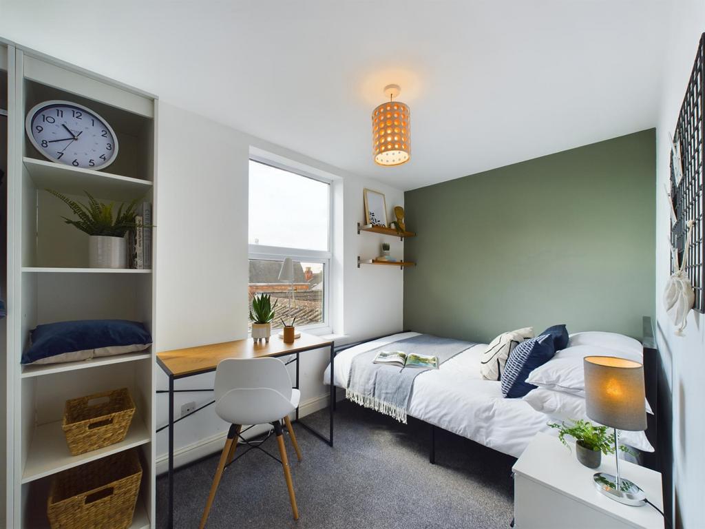 Bright and cozy bedroom featuring a comfortable...