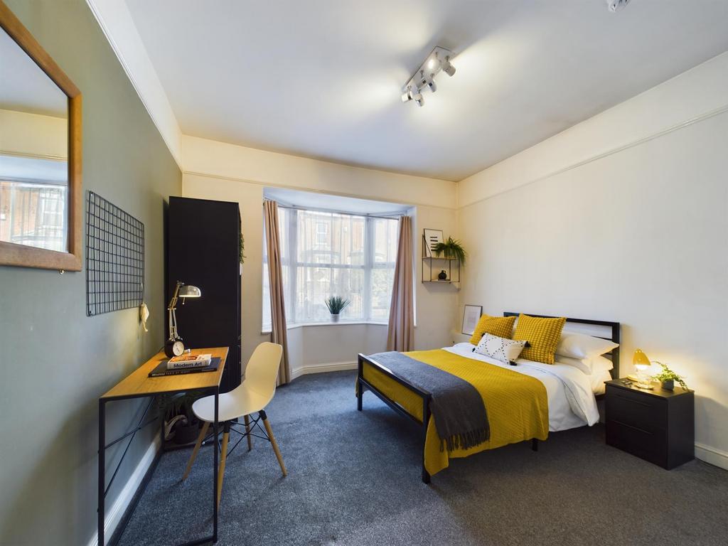 A bright and well-maintained bedroom featuring ...