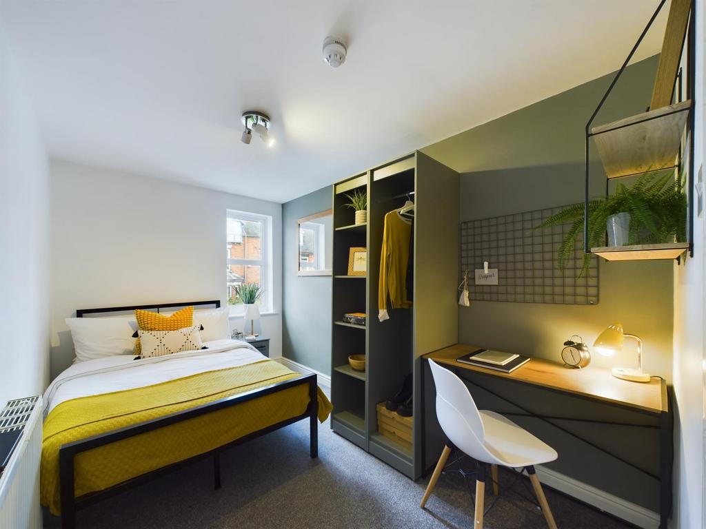 A well-lit and tidy bedroom featuring a stylish...