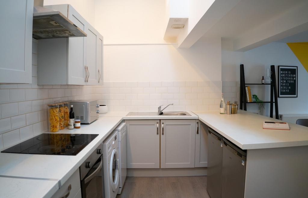A bright and modern kitchenette with ample coun...