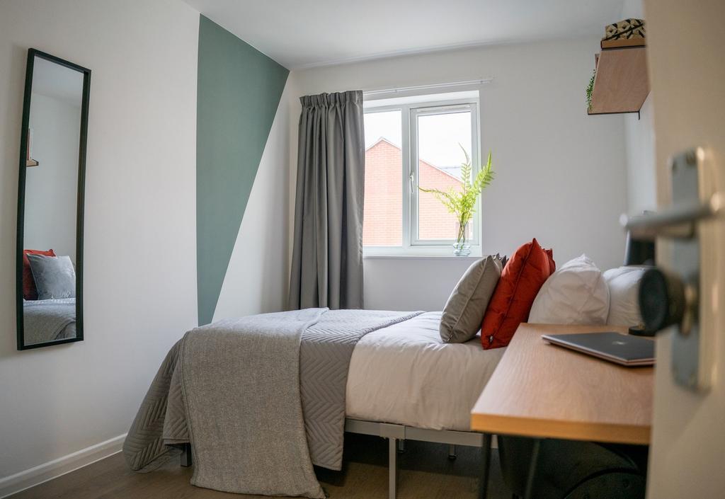 A bright and tidy double bedroom featuring a co...