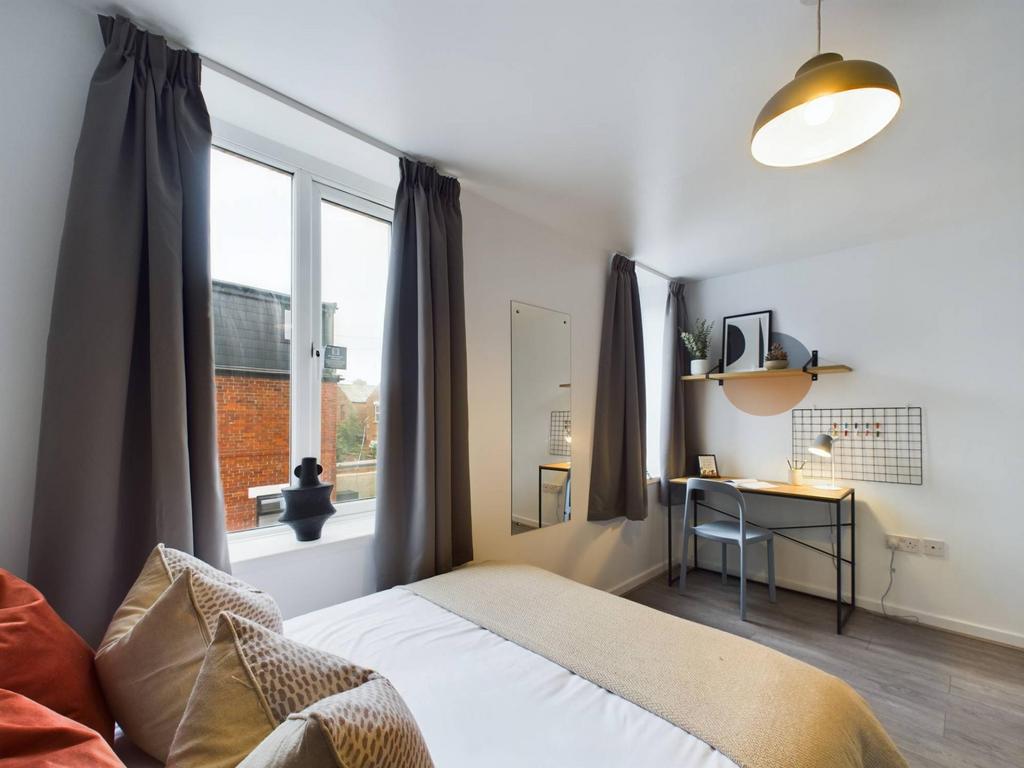 Bright, neatly staged double bedroom with a com...