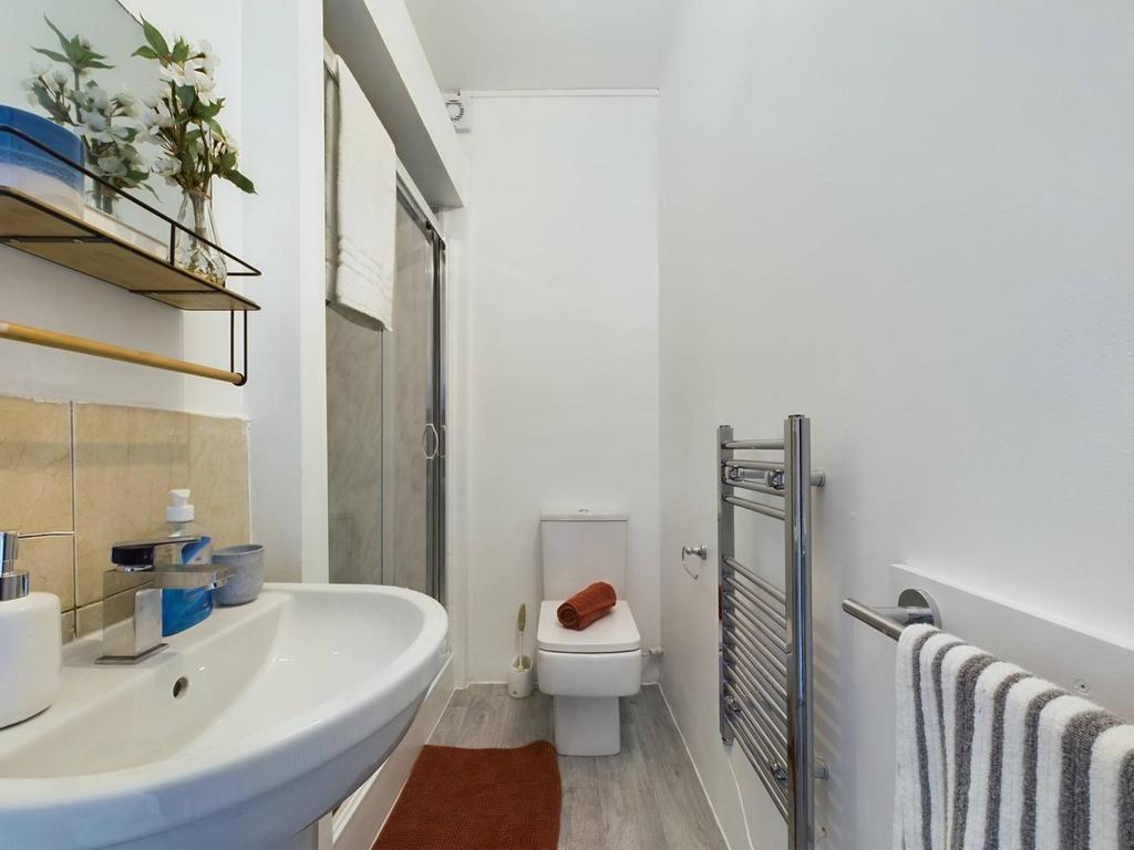 Bright, well-kept bathroom with a pedestal sink...