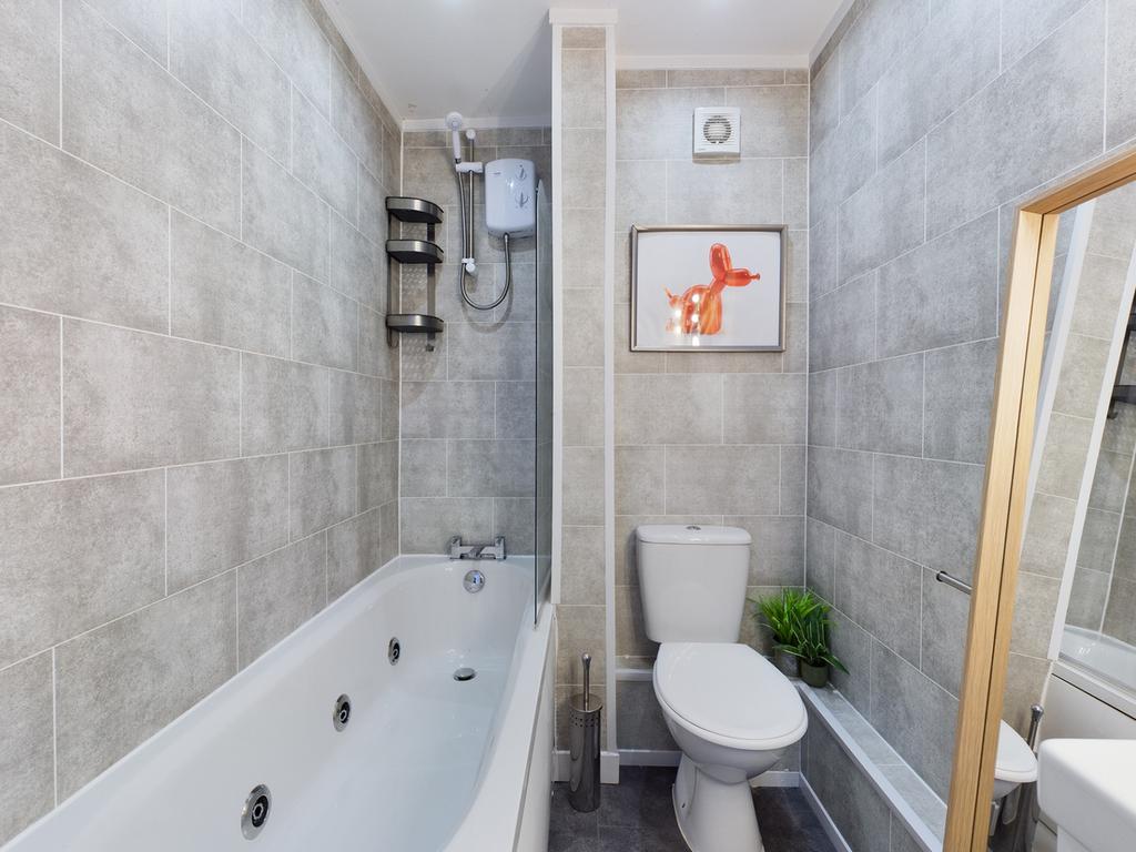 A modern and clean large bathroom featuring a r...