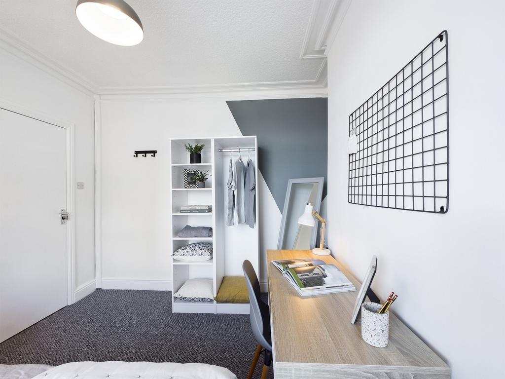 A bright and tidy double bedroom featuring a st...