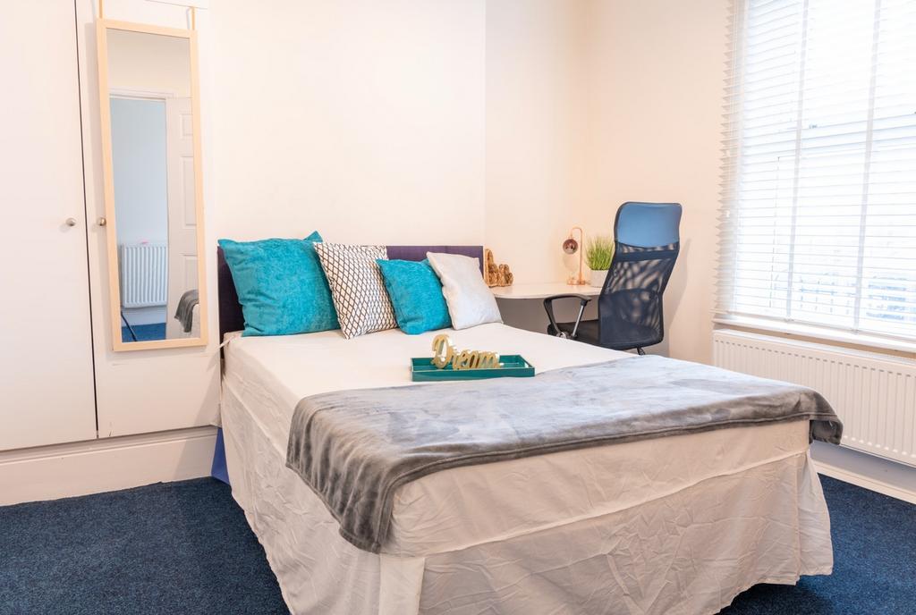 This inviting double bedroom features a comfort...