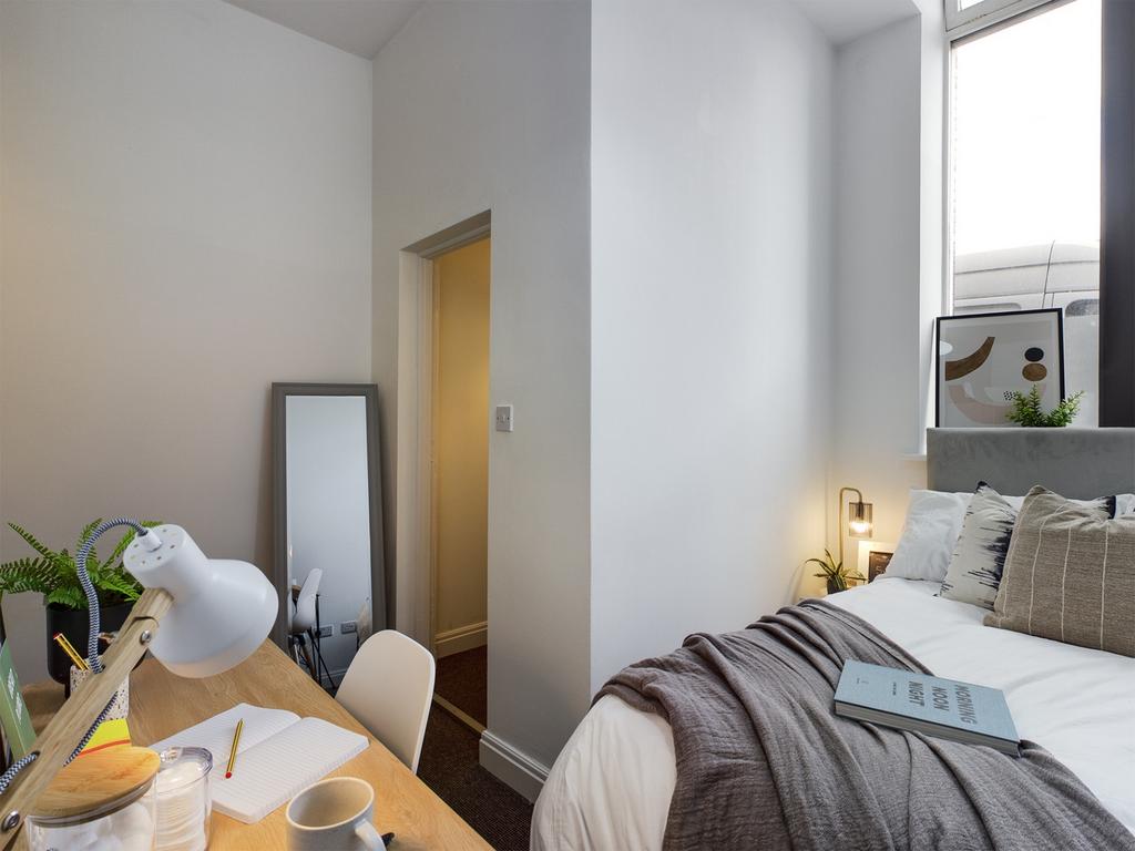 A bright and inviting double bedroom with a coz...