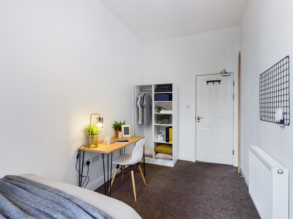 A bright and tidy double bedroom featuring a wo...