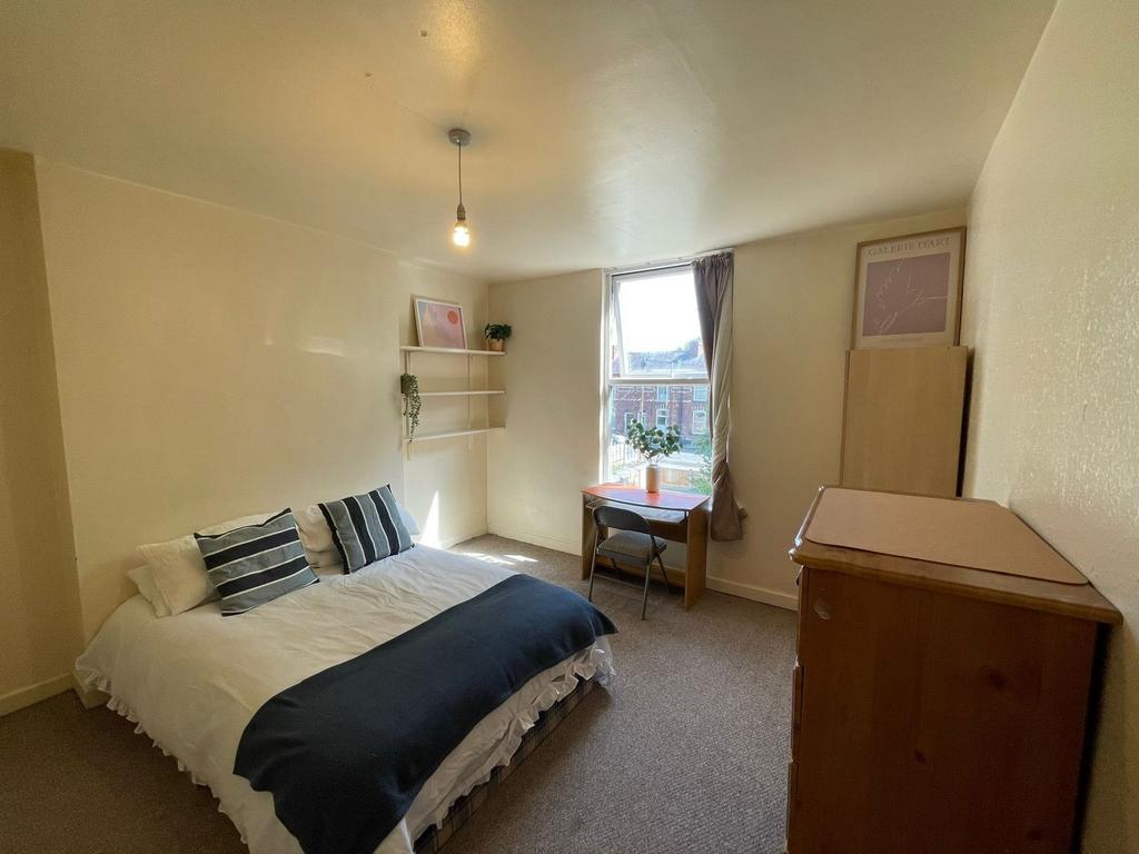 A cozy and well-maintained bedroom featuring a ...