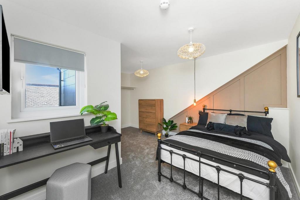 This stylish double bedroom features a comforta...