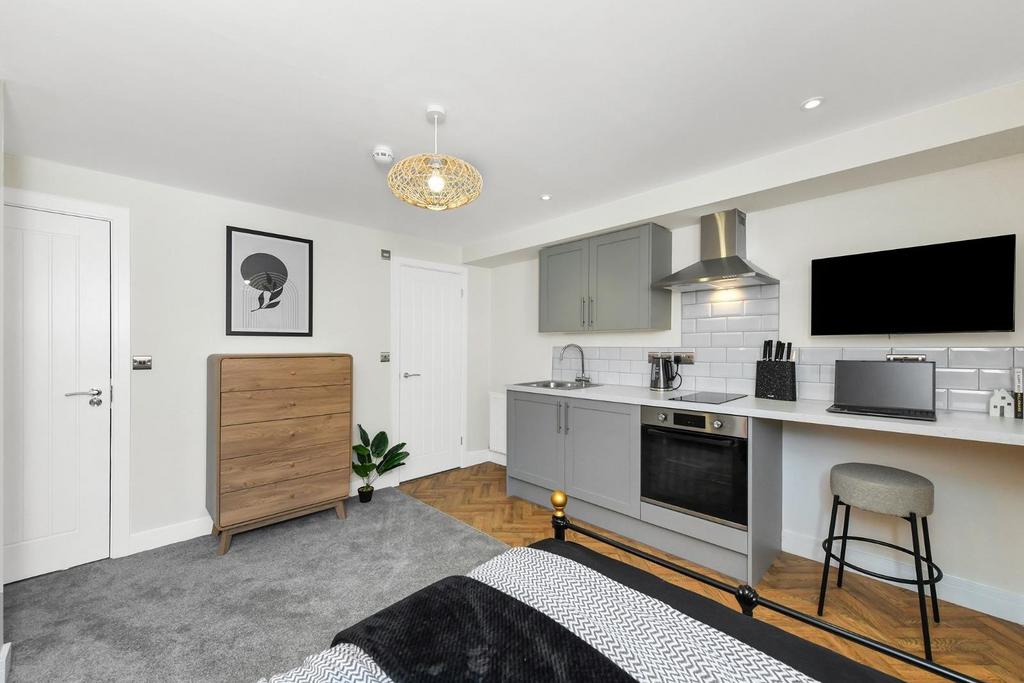 This stylish double bedroom features a cozy des...