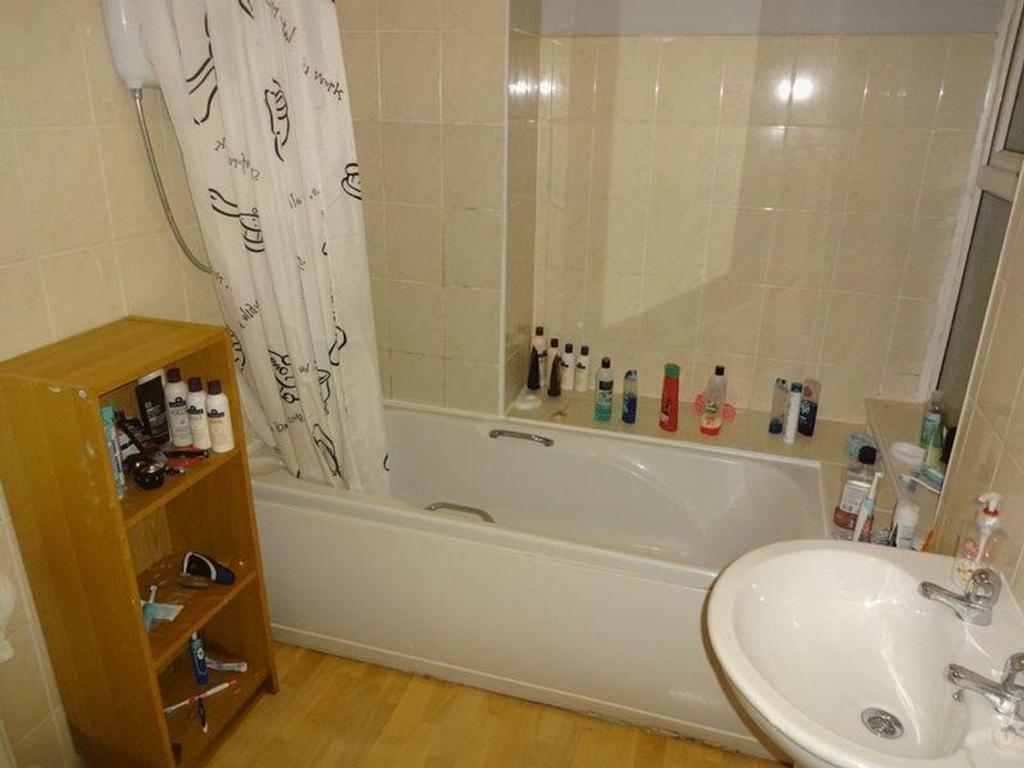A functional bathroom featuring a bathtub and a...